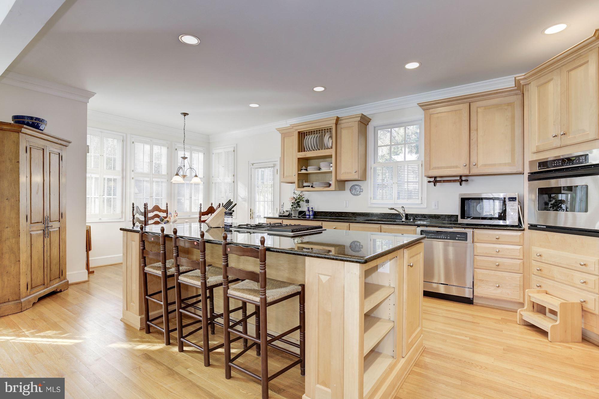 5220 Elliott Road Bethesda, MD 20816 - Photo 12 of 30 a kitchen with stainless steel appliances granite countertop a stove top oven a sink a refrigerator with white cabinets and wooden floor