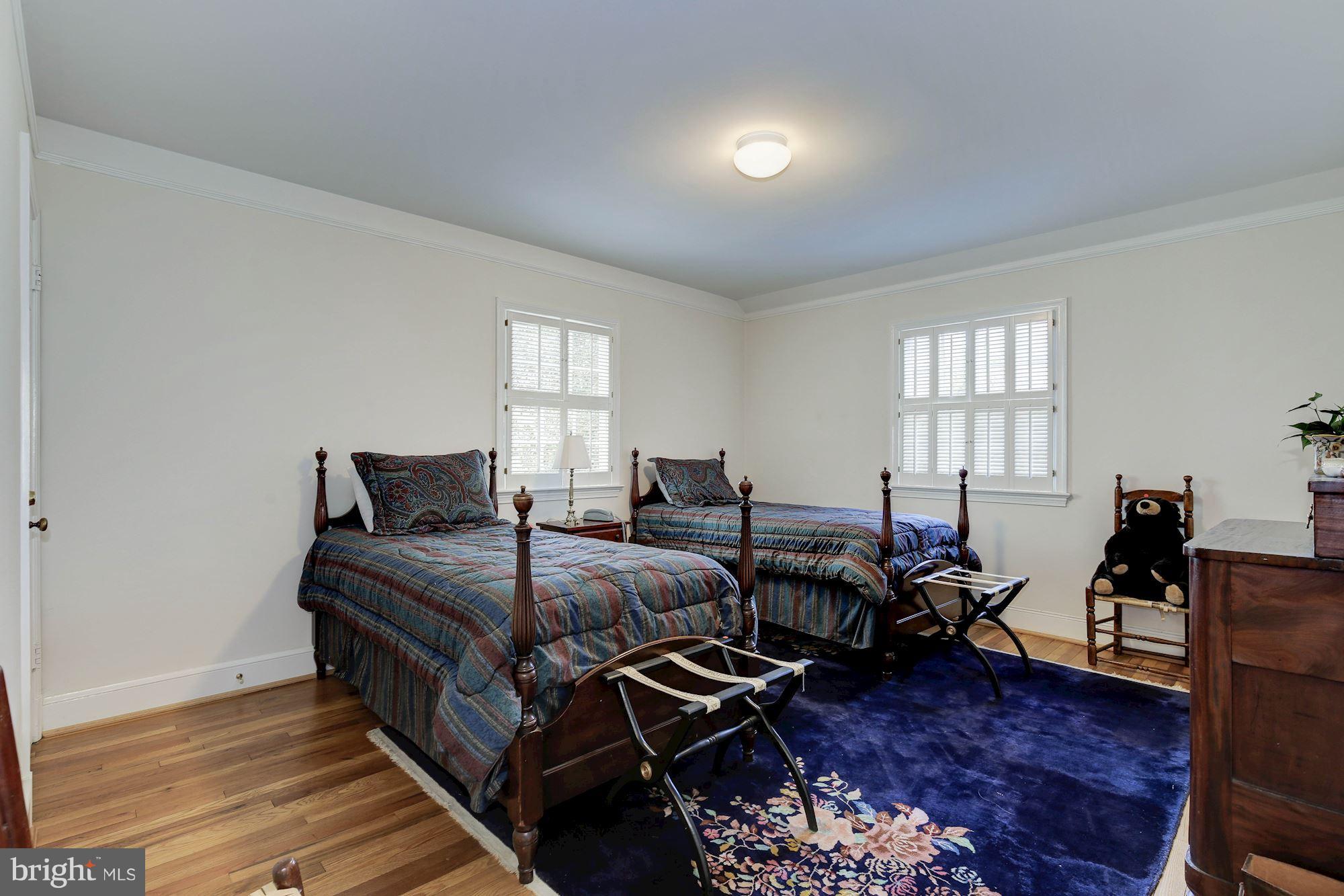 5220 Elliott Road Bethesda, MD 20816 - Photo 19 of 30 a spacious bedroom with a bed and wooden floor
