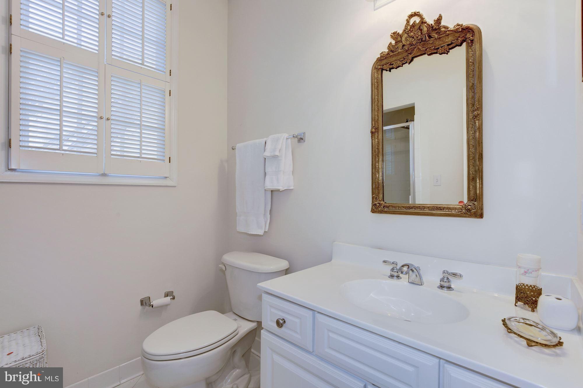 5220 Elliott Road Bethesda, MD 20816 - Photo 22 of 30 a bathroom with a toilet sink vanity and mirror