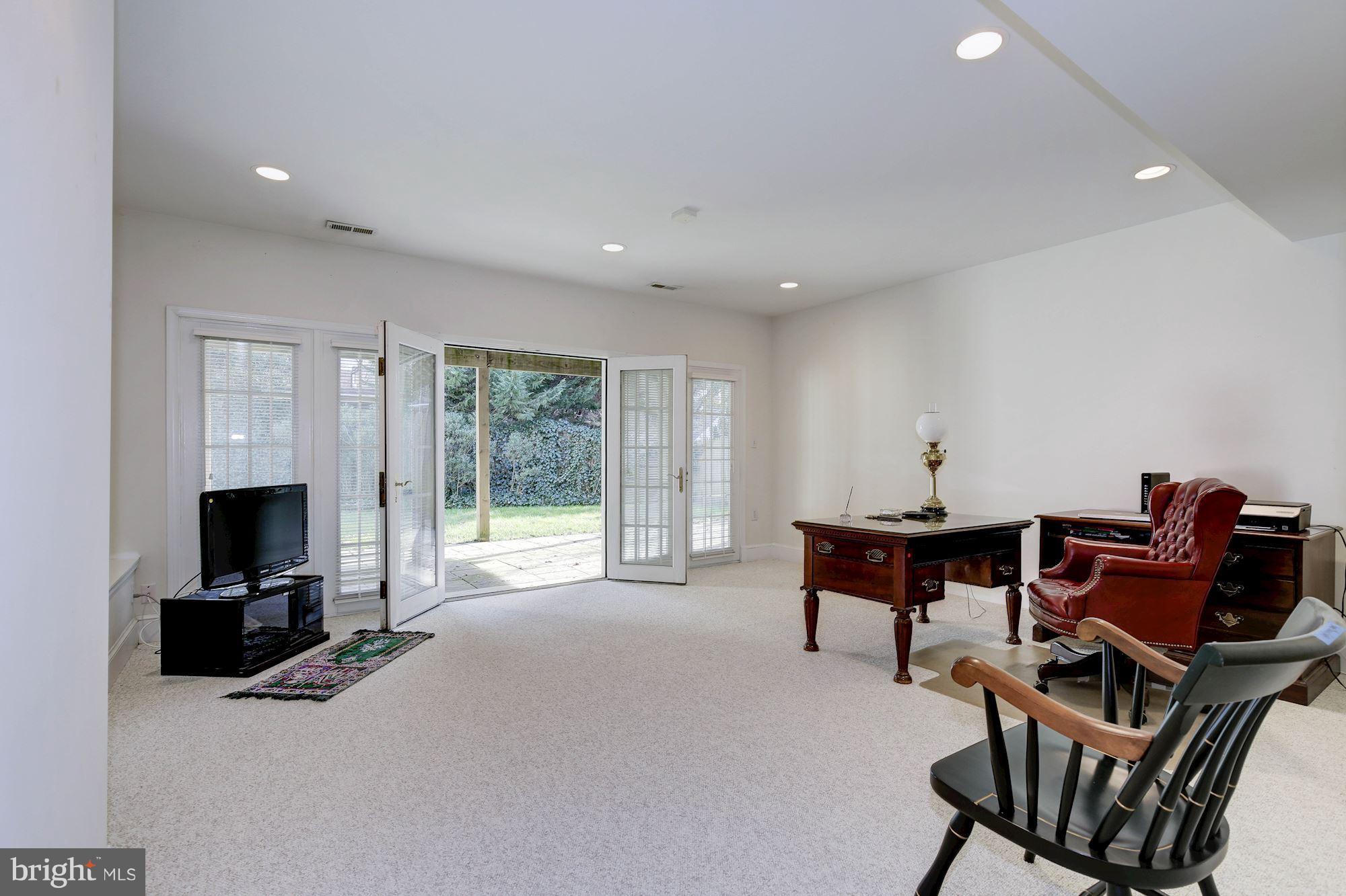 5220 Elliott Road Bethesda, MD 20816 - Photo 24 of 30 a living room with furniture a flat screen tv and floor to ceiling window