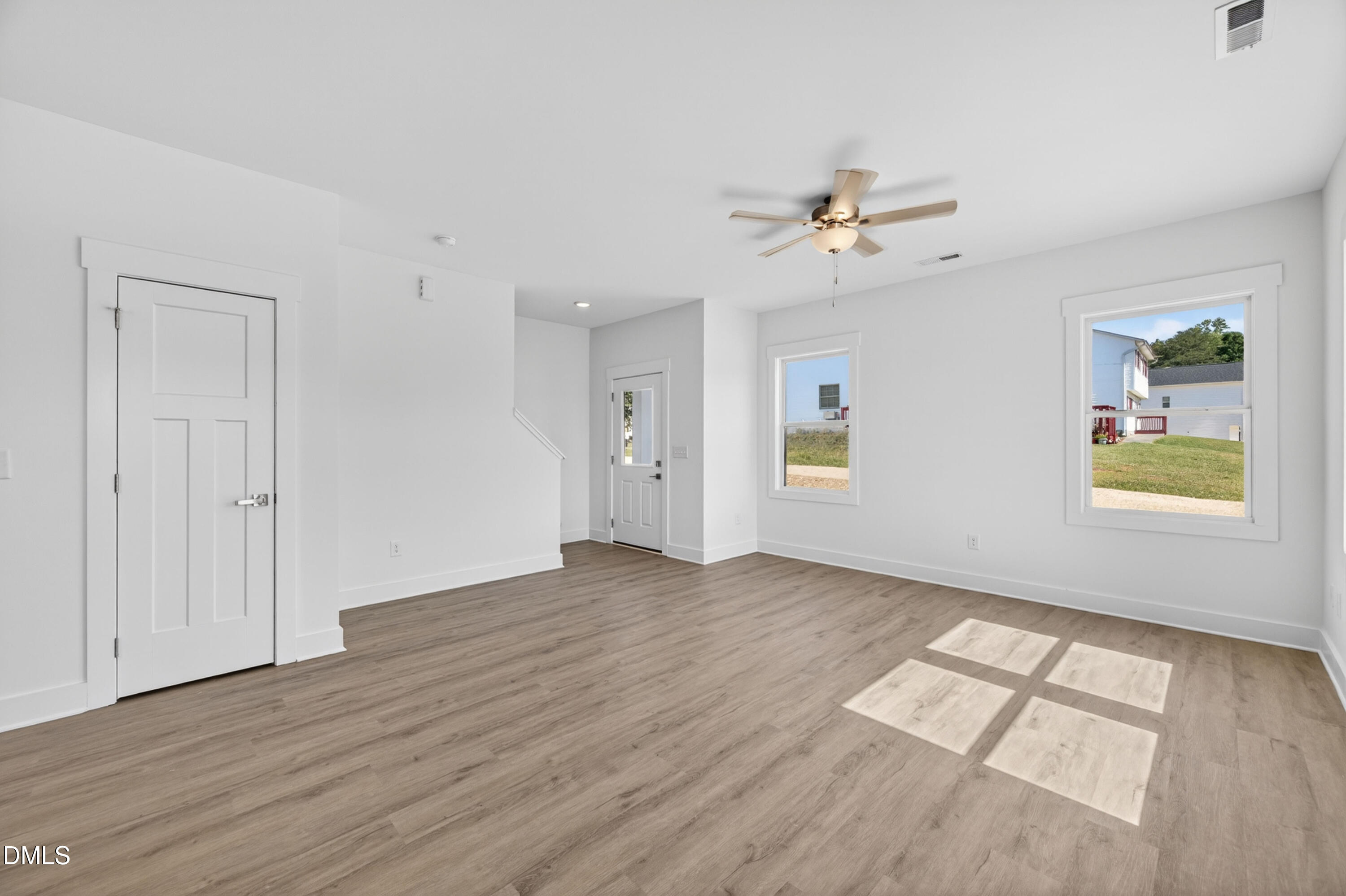 1238 Hurdle Mills Road Roxboro, NC 27573 - Photo 10 of 50 an empty room with wooden floor chandelier fan and windows