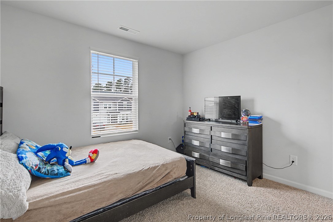 1717 Ennismore Road Hope Mills, NC 28348 - Photo 23 of 33 a bedroom with a bed and a flat screen tv