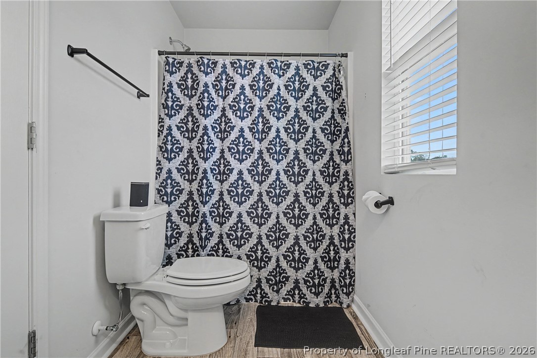 1717 Ennismore Road Hope Mills, NC 28348 - Photo 27 of 33 a bathroom with a toilet and a shower curtain