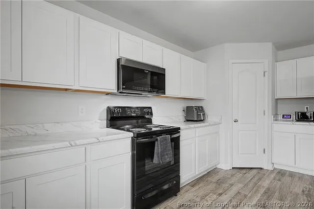 a kitchen with white cabinets stainless steel appliances and sink