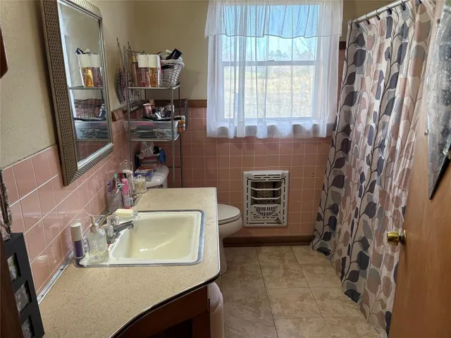 a bathroom with a sink a toilet and a mirror