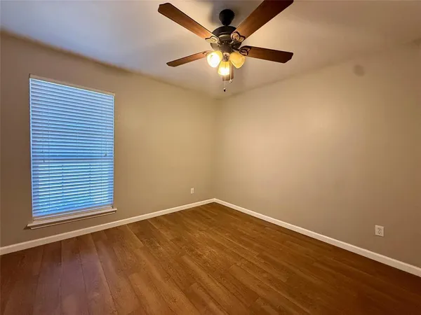 an empty room with a window and a fan