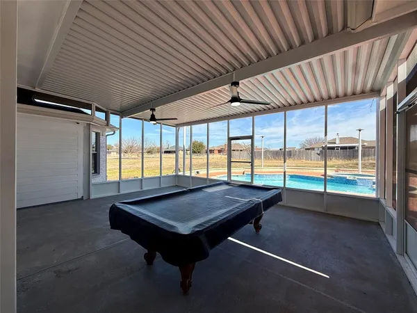 a room with pool table and windows