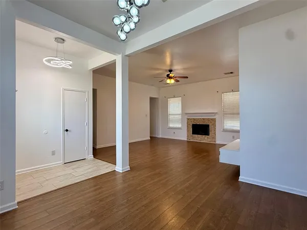 a view of a livingroom with a fireplace wooden floor and chandelier