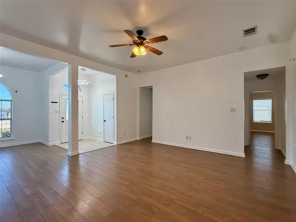 a view of a livingroom with wooden floor and a ceiling fan