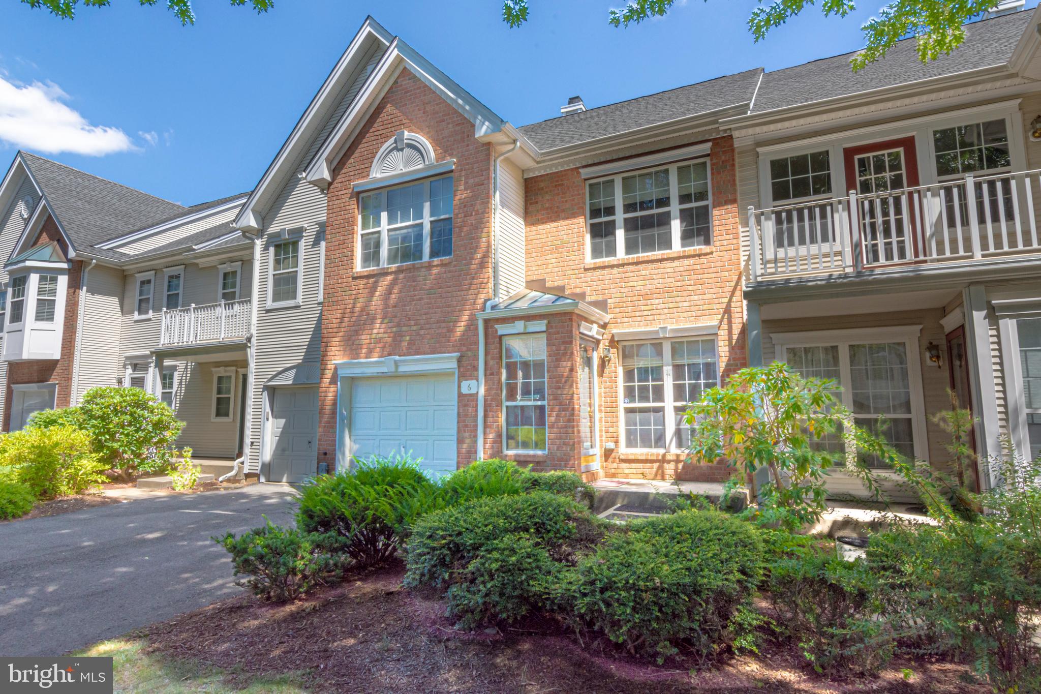 a view of a brick house with a large windows and flower plants