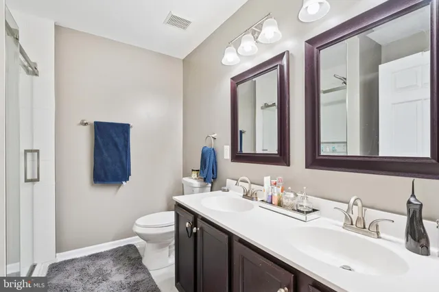 a bathroom with a toilet a sink a mirror and vanity