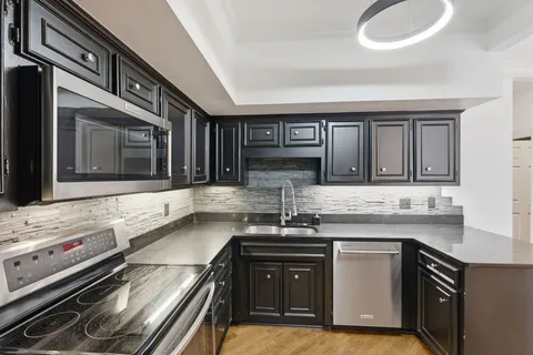 a kitchen with stainless steel appliances granite countertop a sink stove and cabinets