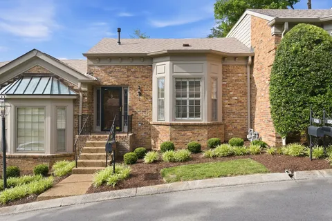 a front view of a house with a yard and potted plants