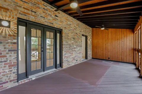 a view of backyard with wooden floor and door