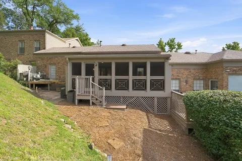 a front view of a house with a garden and furniture