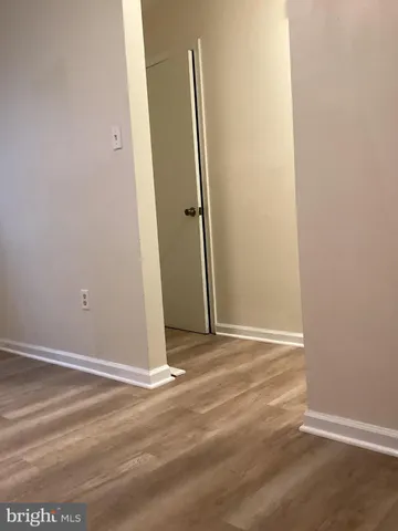 an empty room with wooden floor and a window