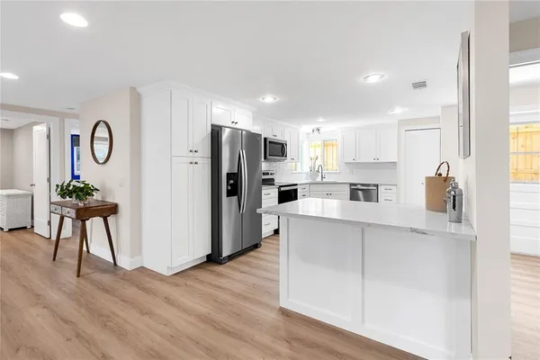 a kitchen with stainless steel appliances a refrigerator and a stove top oven