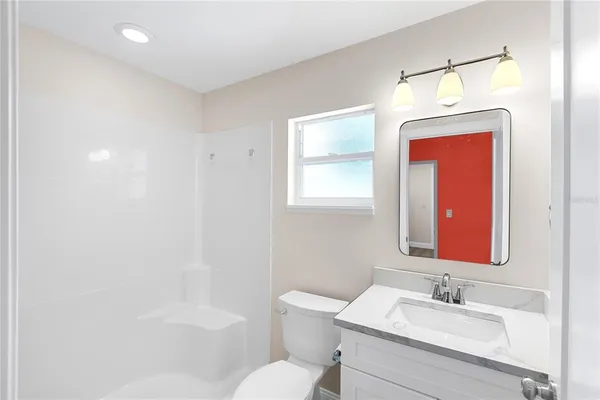 a bathroom with a toilet a sink a mirror and a bathtub