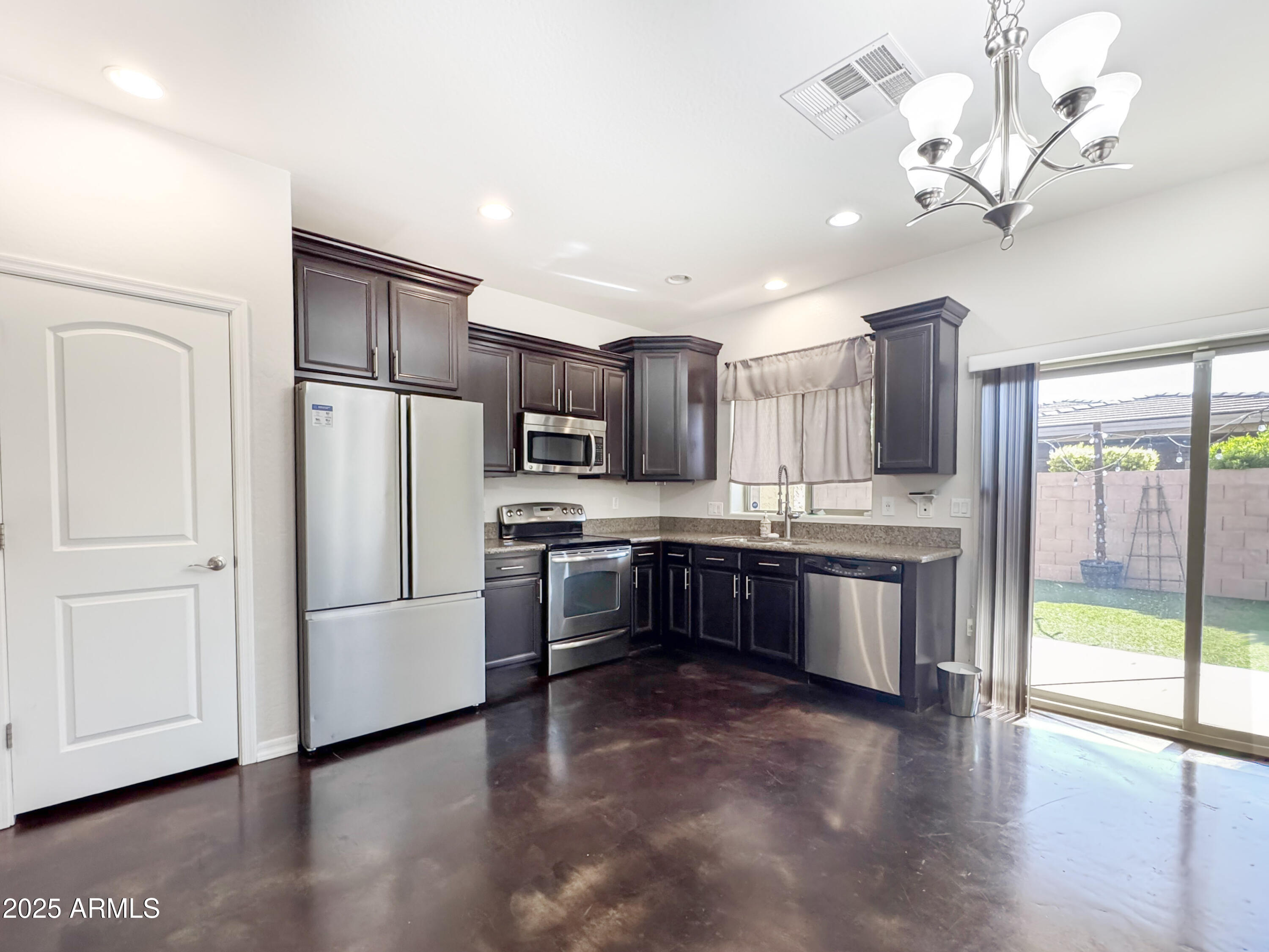 a large kitchen with a large window and stainless steel appliances