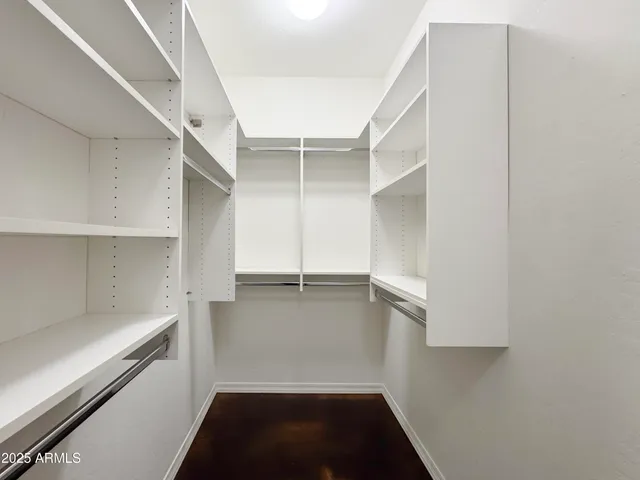 a view of walk in closet with empty racks
