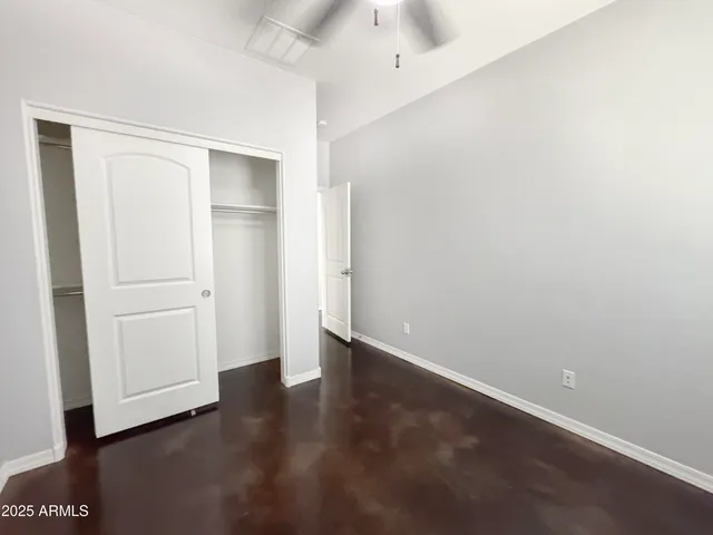 an empty room with a ceiling fan and window