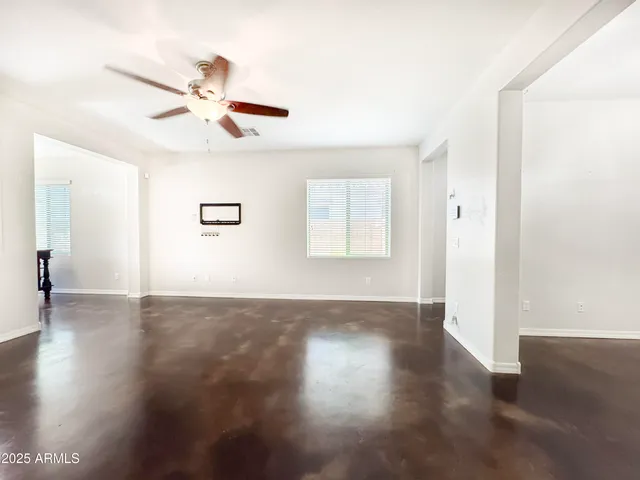a view of a livingroom with wooden floor and a ceiling fan