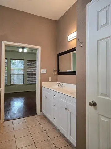 a spacious bathroom with a vanity a mirror and a sink