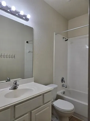 a bathroom with a sink a toilet a mirror and shower