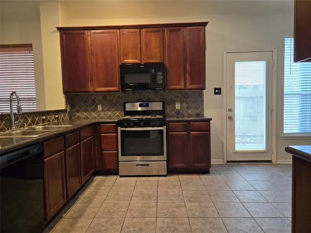 a kitchen with a stove a sink and a microwave