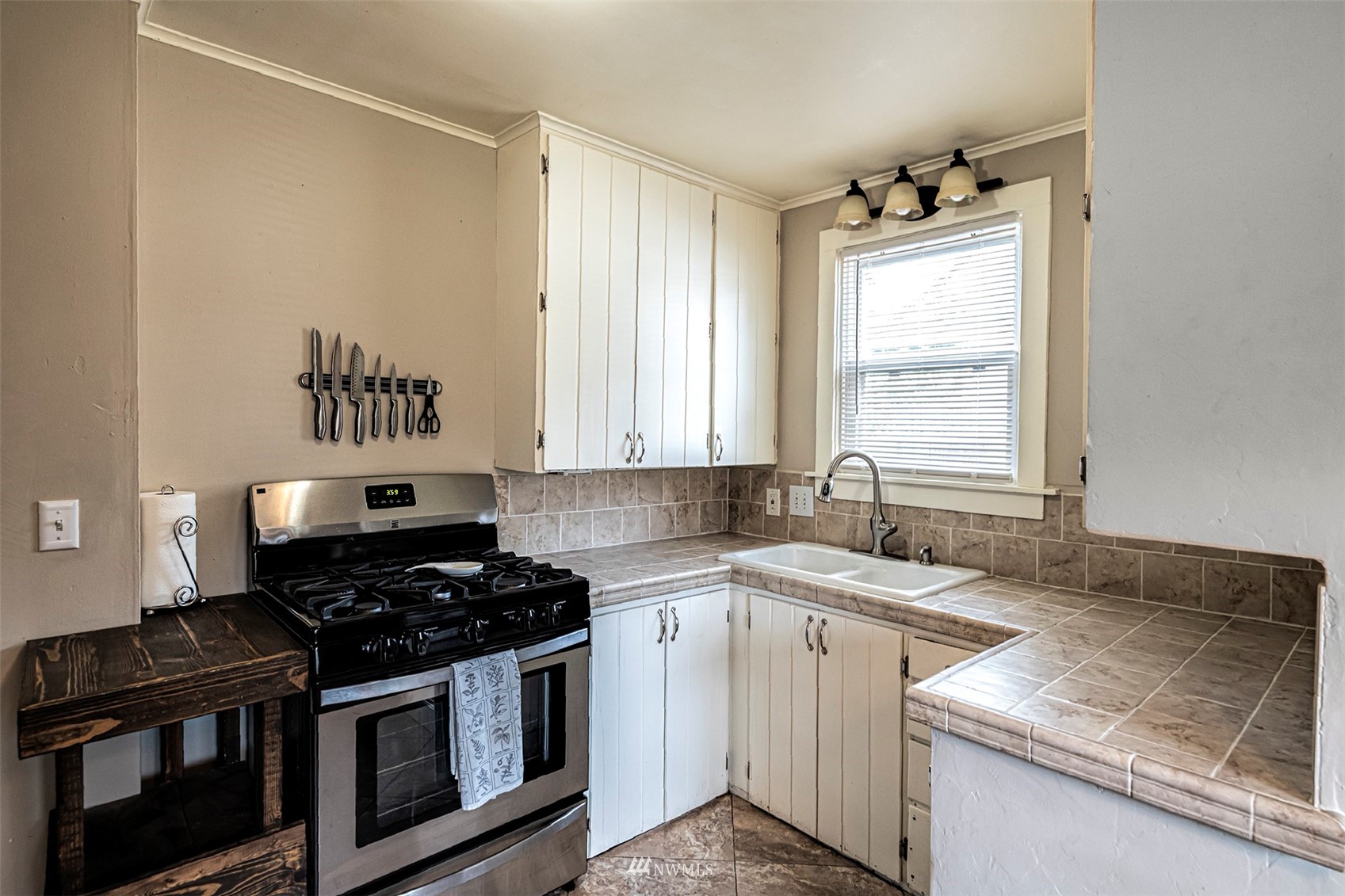 152 Locust Street Walla Walla, WA 99362 - Photo 16 of 38 a kitchen with granite countertop a stove sink and cabinets