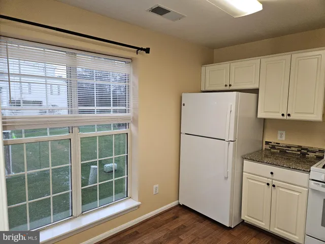 a white refrigerator freezer and a wooden cabinets