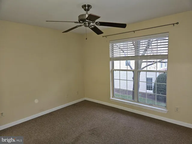 a view of a room with a window and a ceiling fan