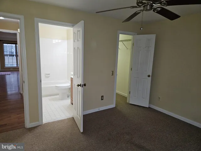 an empty room with closet and a chandelier fan