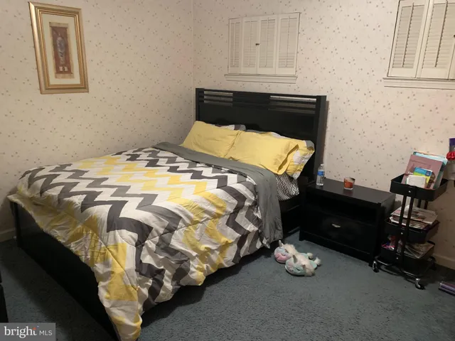 a bed sitting in a bedroom next to a window