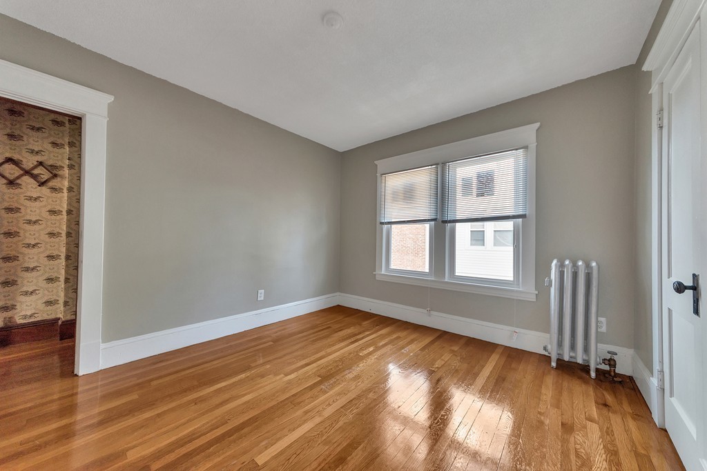 17-19 Standish Street Springfield, MA 01108 - Photo 9 of 20 an empty room with wooden floor and windows