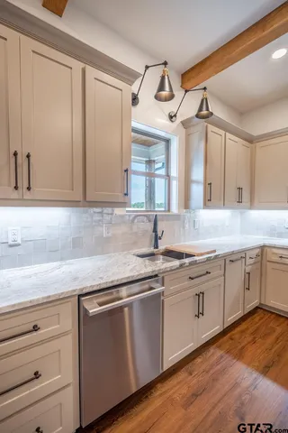 a kitchen with granite countertop stainless steel appliances sink and cabinets