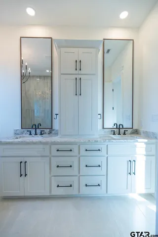 a bathroom with double vanity sink and mirror