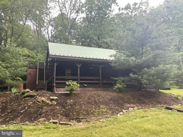 a view of a house with a yard and large tree