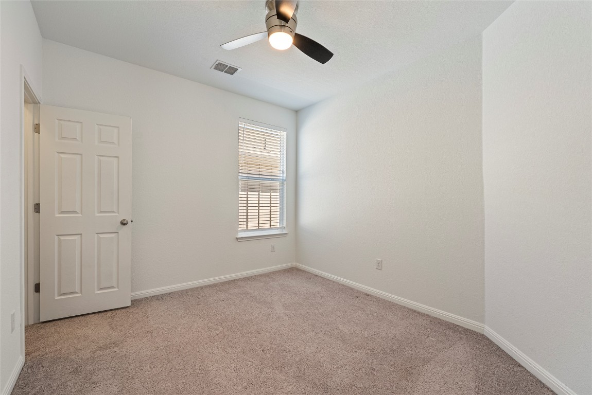 10704 Sentinel Drive Austin, TX 78747 - Photo 13 of 22 Unfurnished room with light carpet and ceiling fan