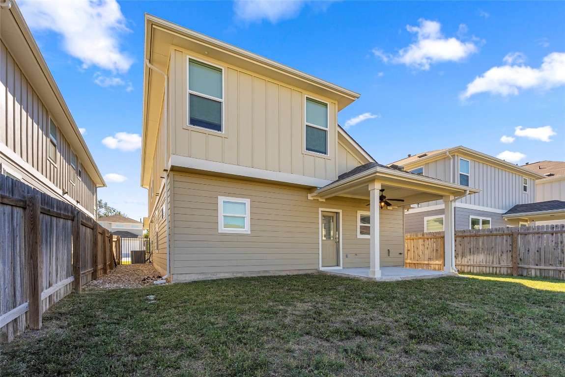 10704 Sentinel Drive Austin, TX 78747 - Photo 19 of 22 Back of house with a patio, a fenced backyard, board and batten siding, and ceiling fan