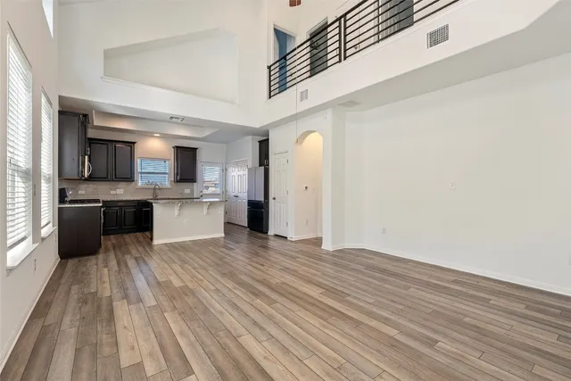 a view of a yard in front of a house with plants and large tree