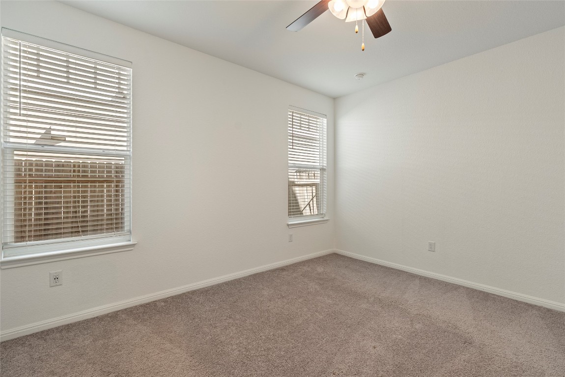 10704 Sentinel Drive Austin, TX 78747 - Photo 7 of 22 Carpeted empty room with baseboards and ceiling fan
