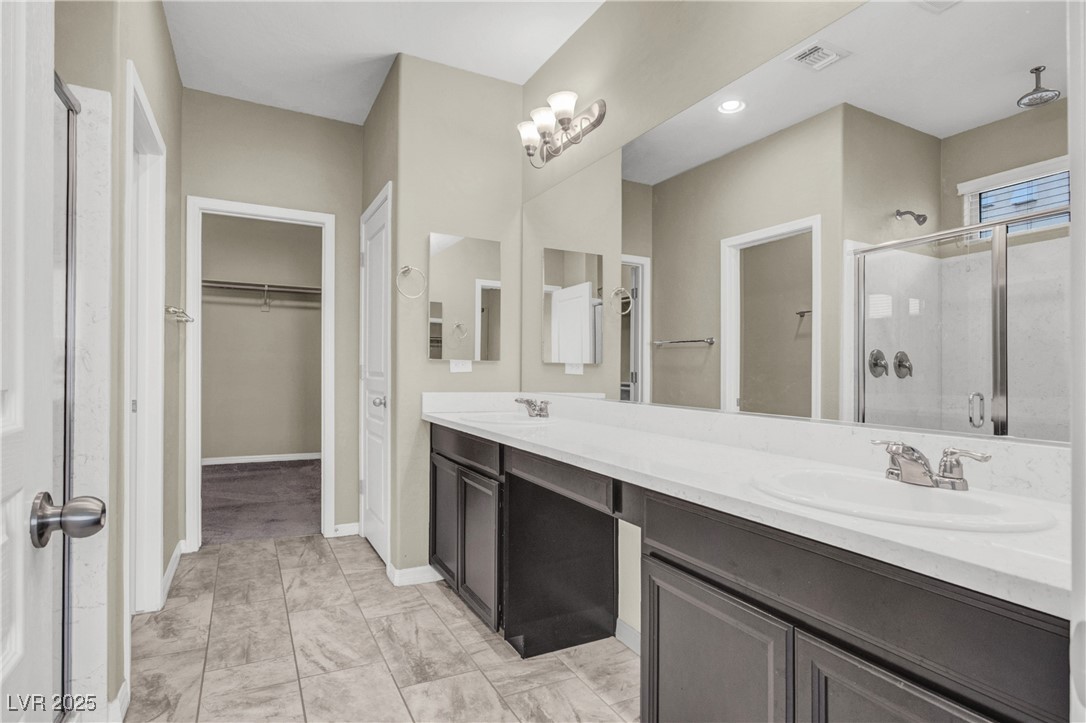 10976 Bluebell Basin Road Las Vegas, NV 89179 - Photo 12 of 40 Full bath with a shower stall, a walk in closet, double vanity, marble look tile flooring, and baseboards