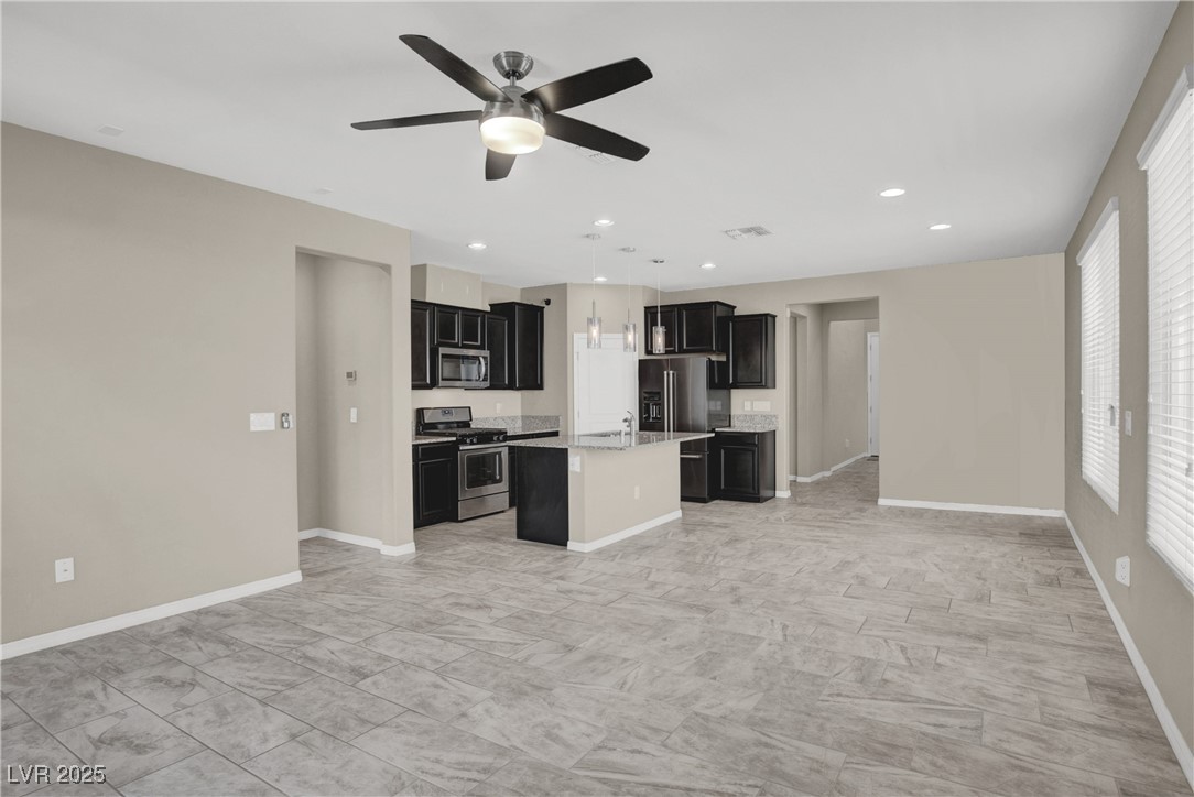 10976 Bluebell Basin Road Las Vegas, NV 89179 - Photo 40 of 40 Kitchen featuring stainless steel appliances, open floor plan, dark cabinets, healthy amount of natural light, and recessed lighting