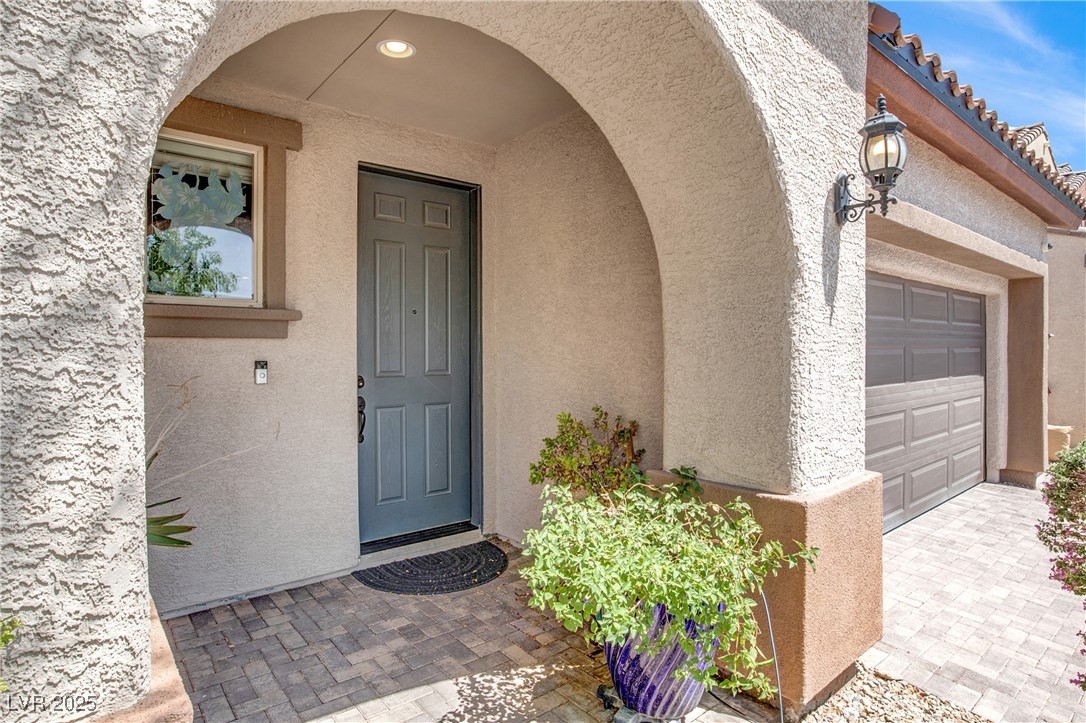 10976 Bluebell Basin Road Las Vegas, NV 89179 - Photo 3 of 40 View of exterior entry featuring stucco siding and a garage