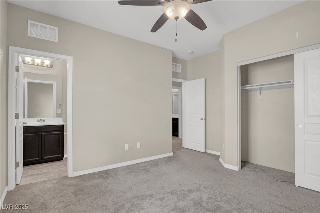 10976 Bluebell Basin Road Las Vegas, NV 89179 - Photo 32 of 40 Unfurnished bedroom featuring light carpet, a closet, and baseboards