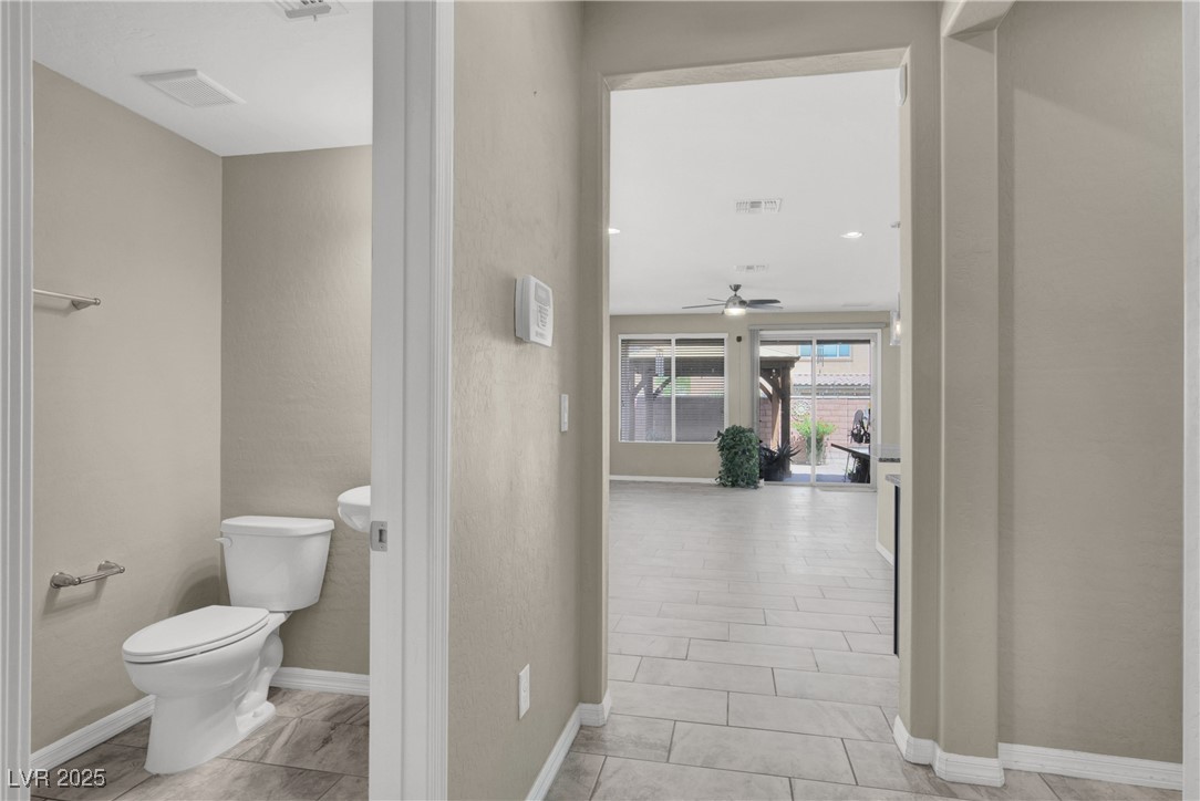10976 Bluebell Basin Road Las Vegas, NV 89179 - Photo 5 of 40 Bathroom with toilet, a ceiling fan, and baseboards