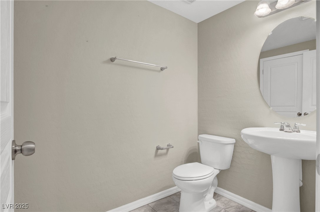 10976 Bluebell Basin Road Las Vegas, NV 89179 - Photo 6 of 40 Bathroom with toilet, baseboards, tile patterned floors, and a sink