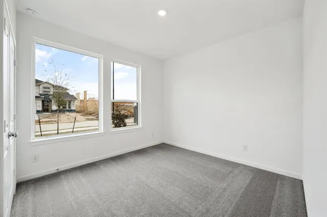 a view of an empty room with closet and a bathroom