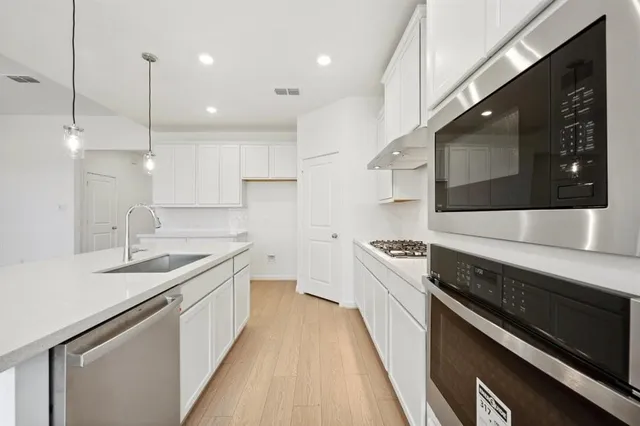 a kitchen with stainless steel appliances a sink stove and cabinets